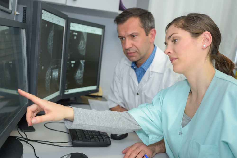 Doctor,And,Technician,Analyzing,Brain,Xrays,On,Computer
